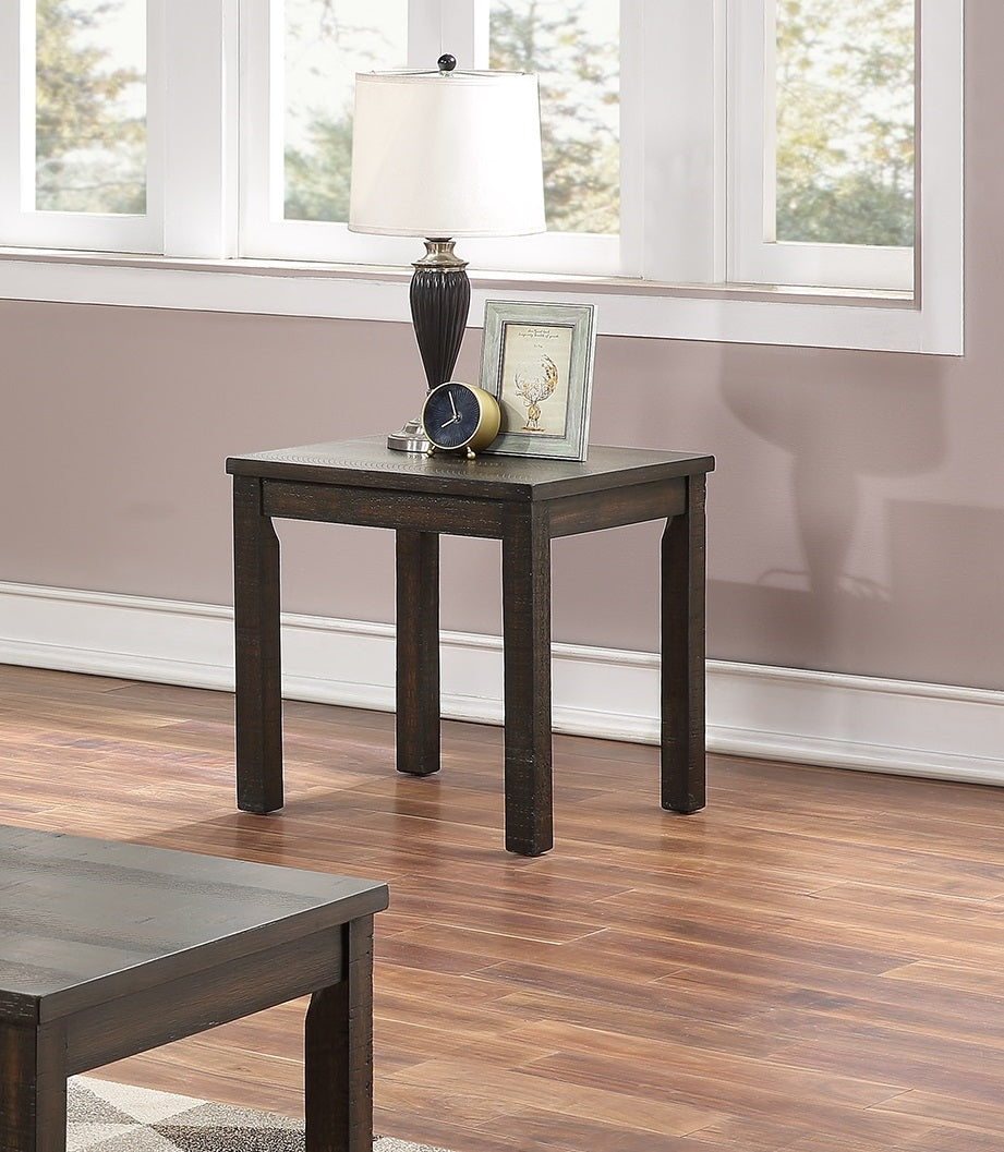 Dark wood end table with carved detailing and a decorative lamp
