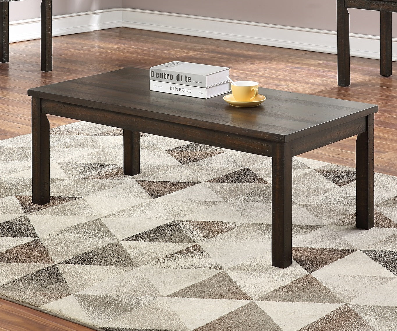 Dark brown wood coffee table with tapered legs on geometric rug