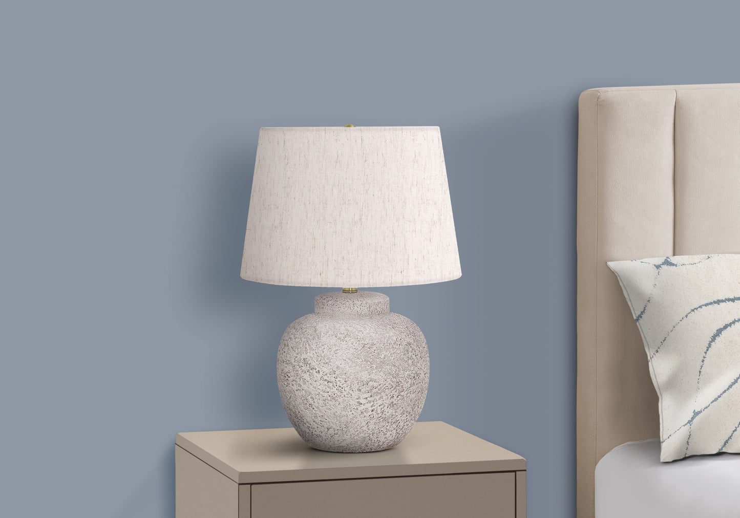 Textured ceramic table lamp with offwhite shade on beige nightstand