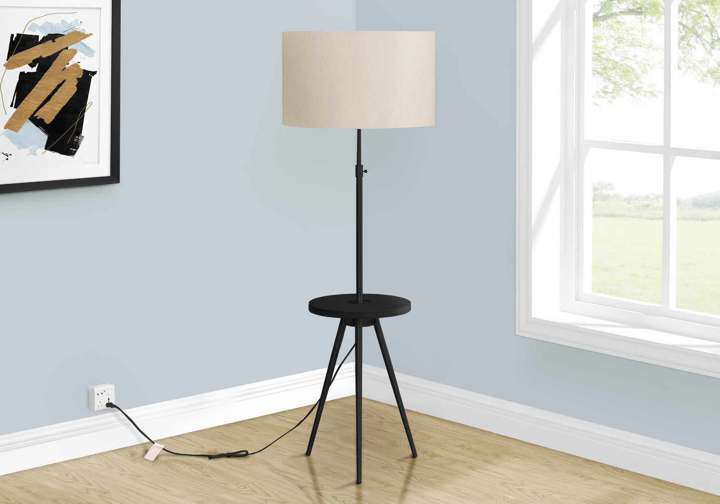 Black metal tripod floor lamp with round side table and beige drum shade