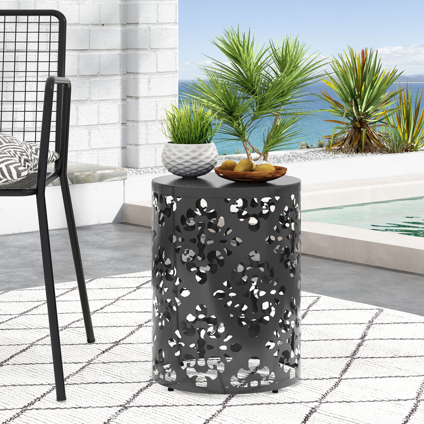 Round metal side table with abstract cutouts perfect for patio use