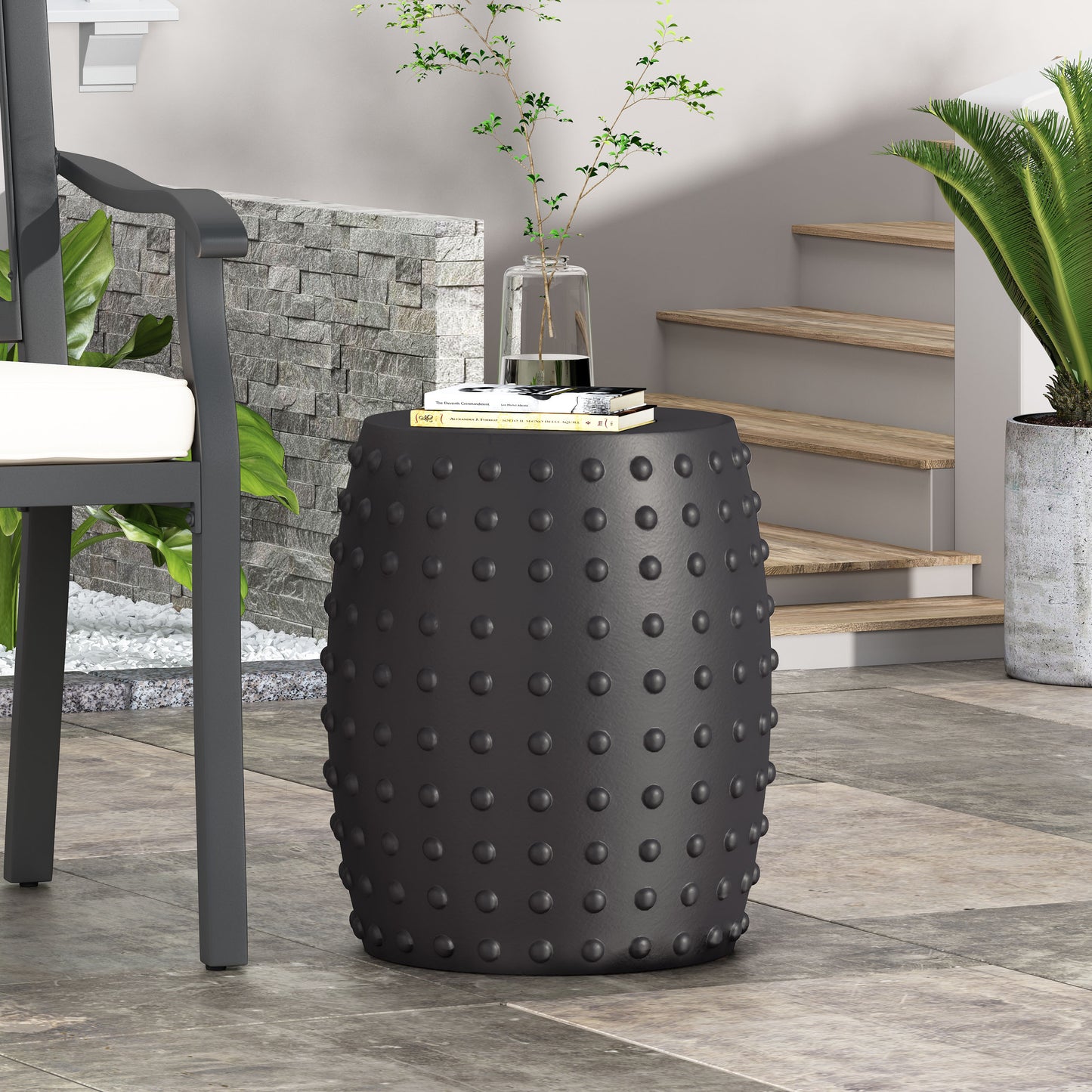 Black ceramic garden stool with raised stud texture and classic drum shape