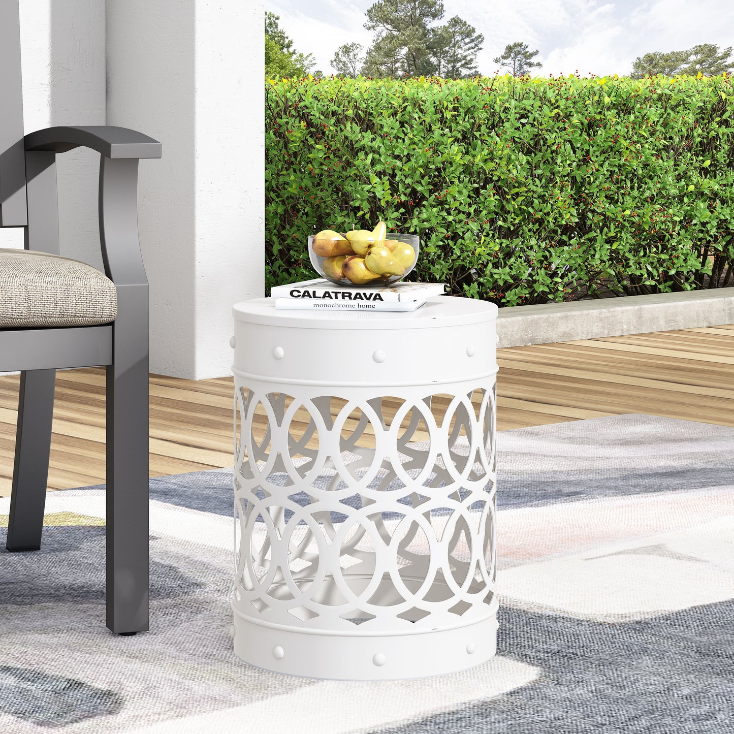 White metal garden stool with ornate circular cutouts and studded details
