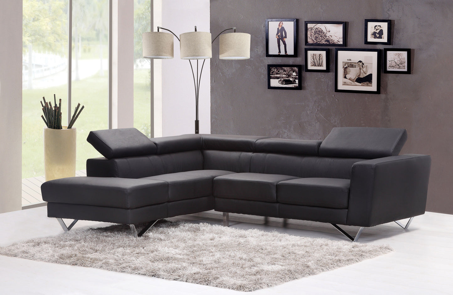 Dark gray leather sectional sofa with chrome legs on a plush rug