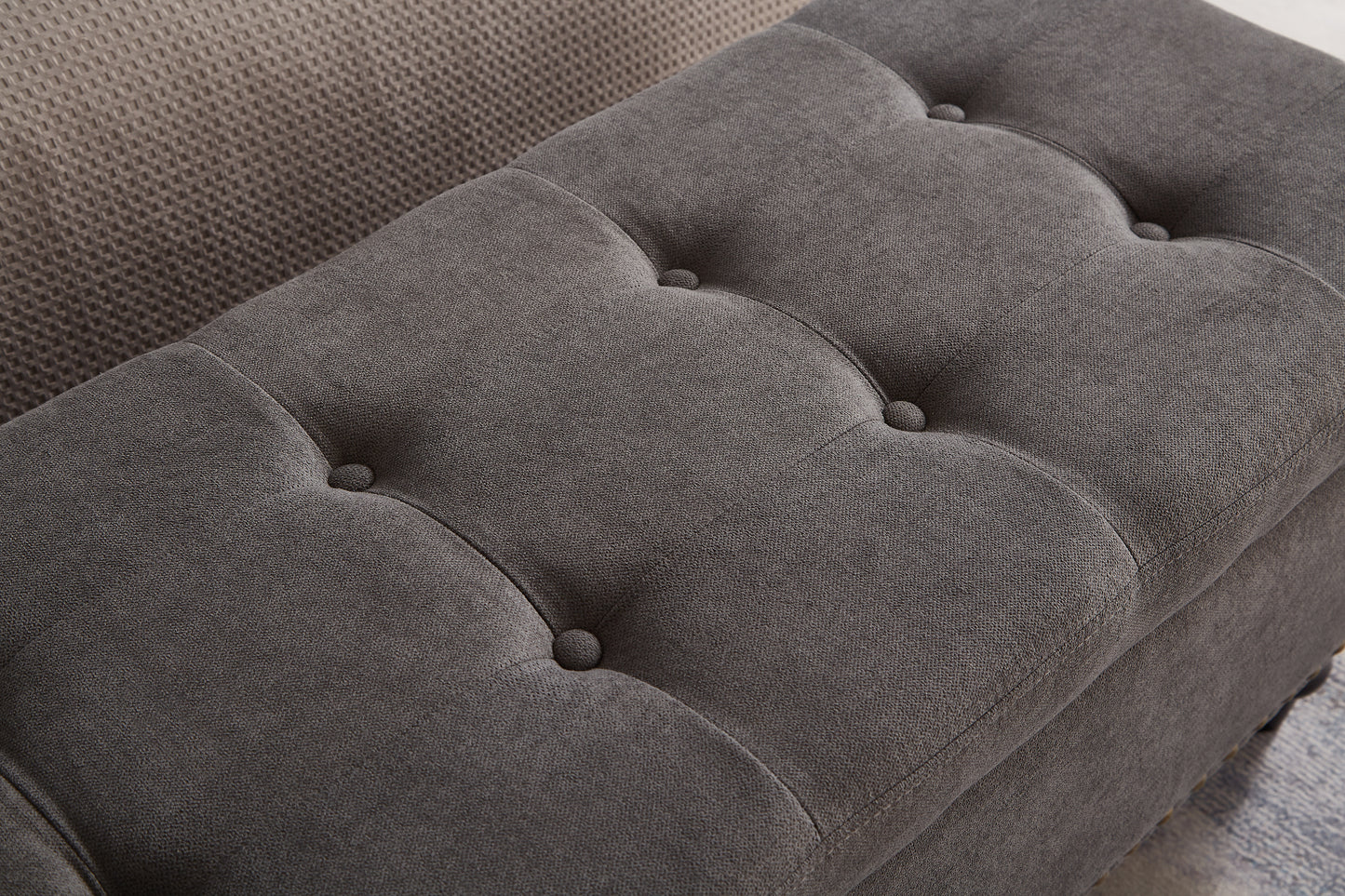 Dark grey fabric storage ottoman with button tufting