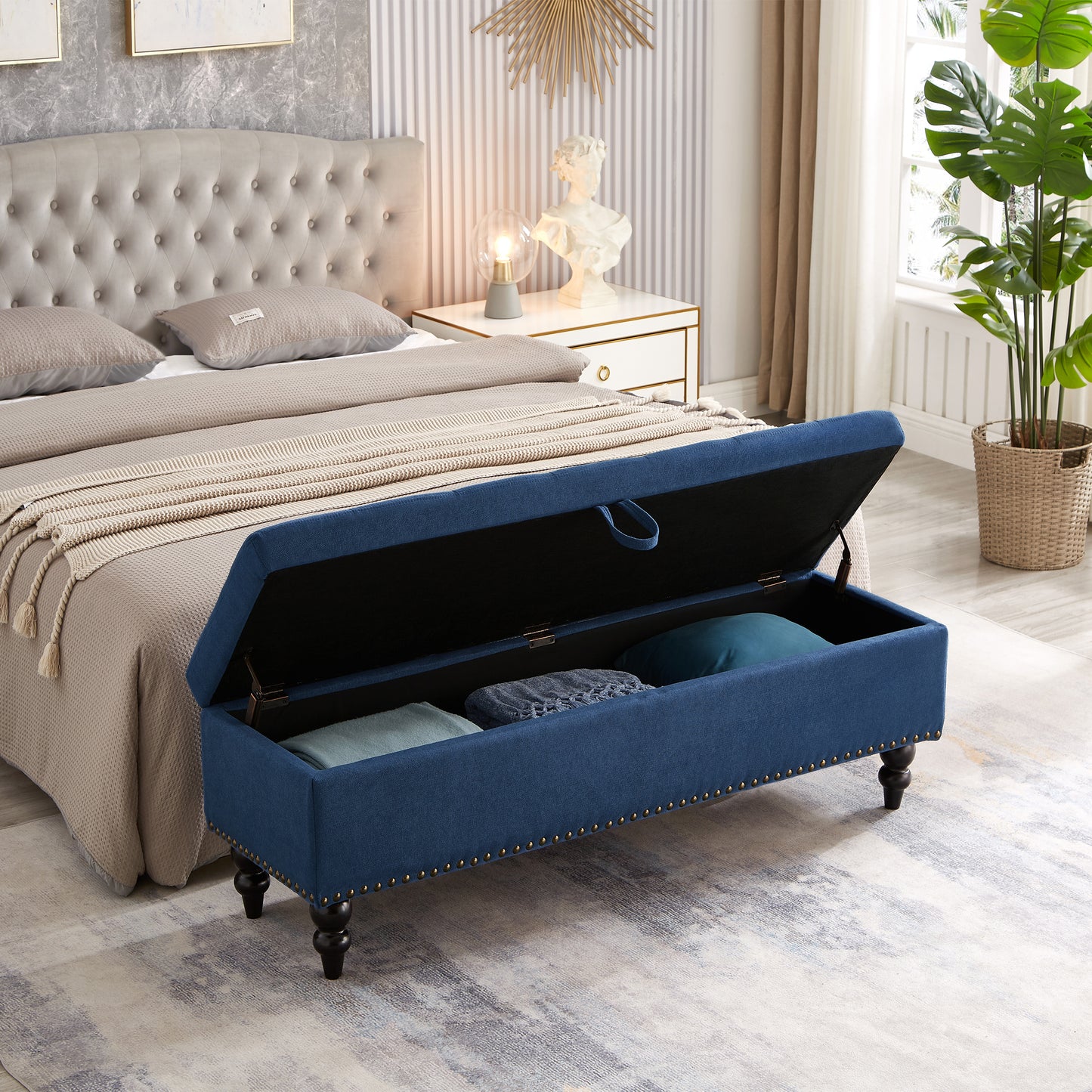 Navy blue upholstered storage bench with brass nailhead trim