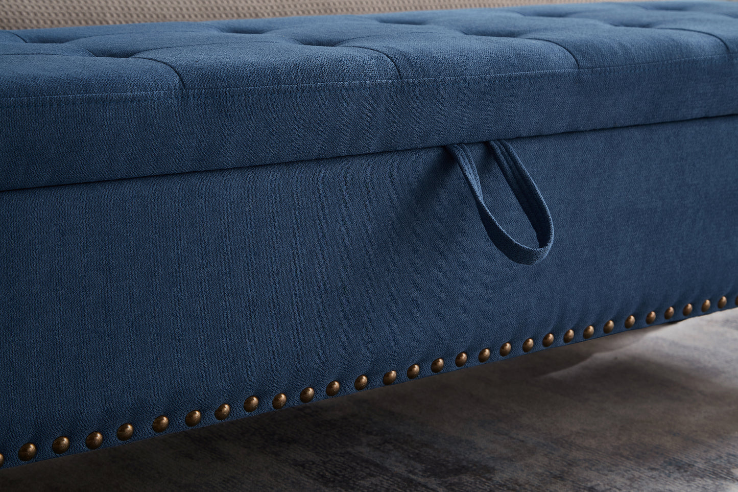 Navy blue storage ottoman with button tufting and brass nailhead trim