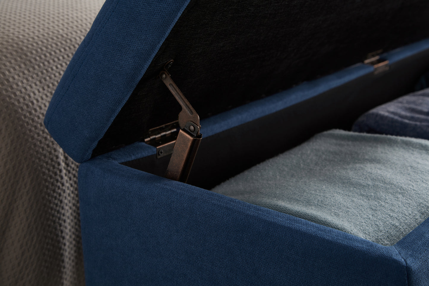 Navy blue ottoman storage unit with textured fabric and metal hinge
