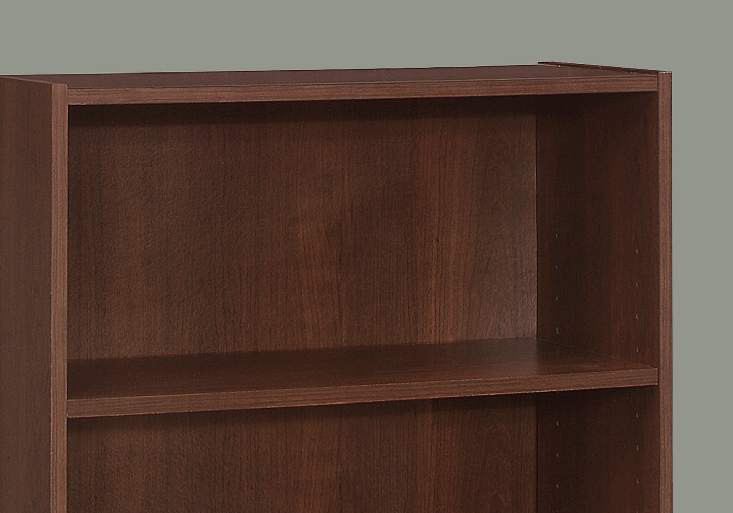 Closeup of dark wood veneer bookshelf one shelf visible