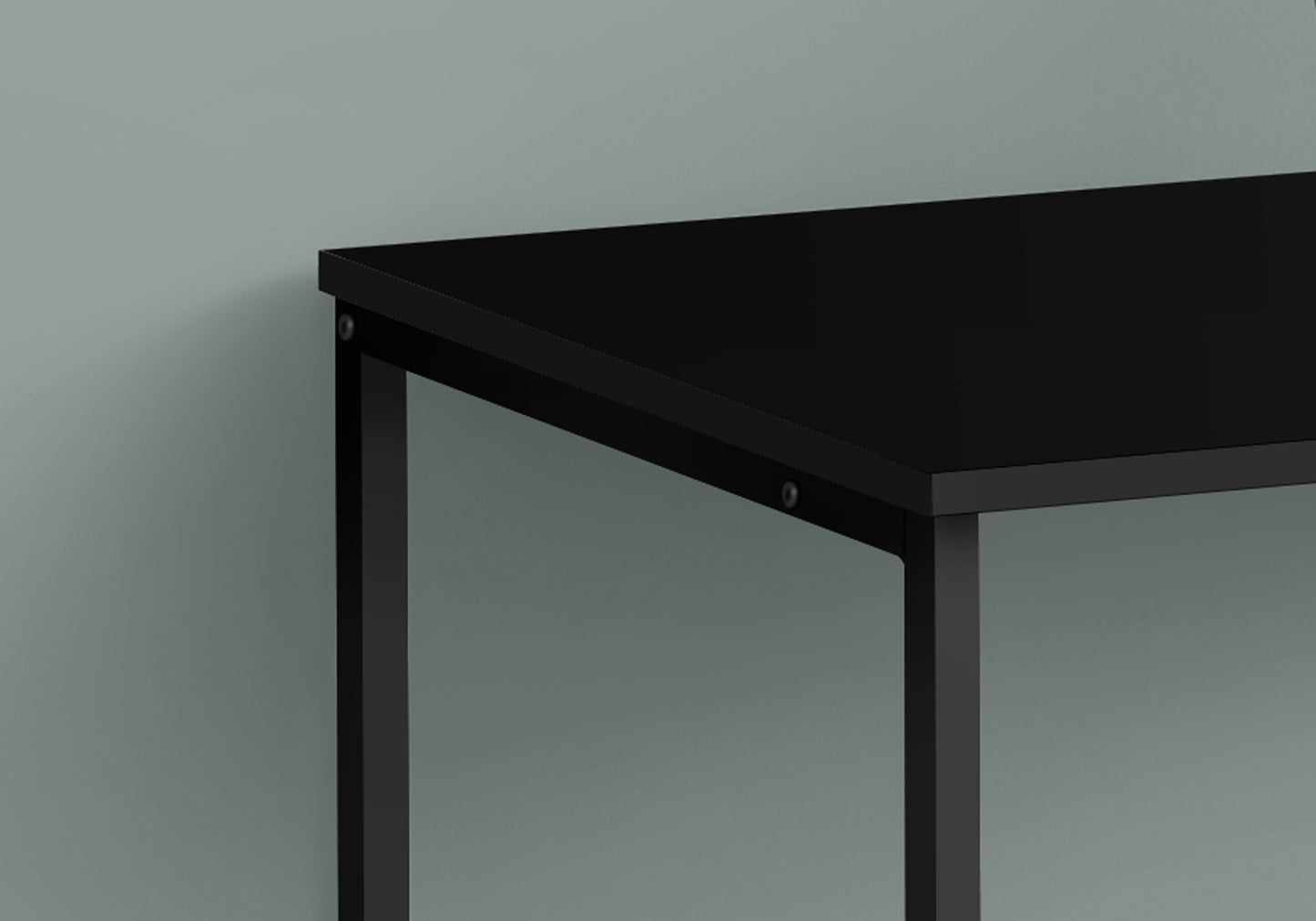 Closeup of a sleek black metal desk frame with a matching matte black tabletop