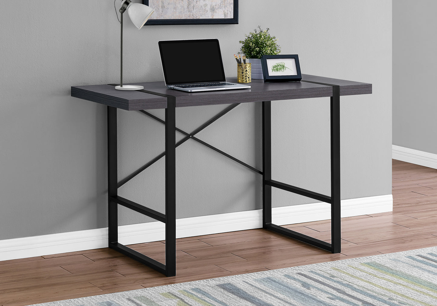 Dark wood grain compact desk with black metal frame laptop and lamp