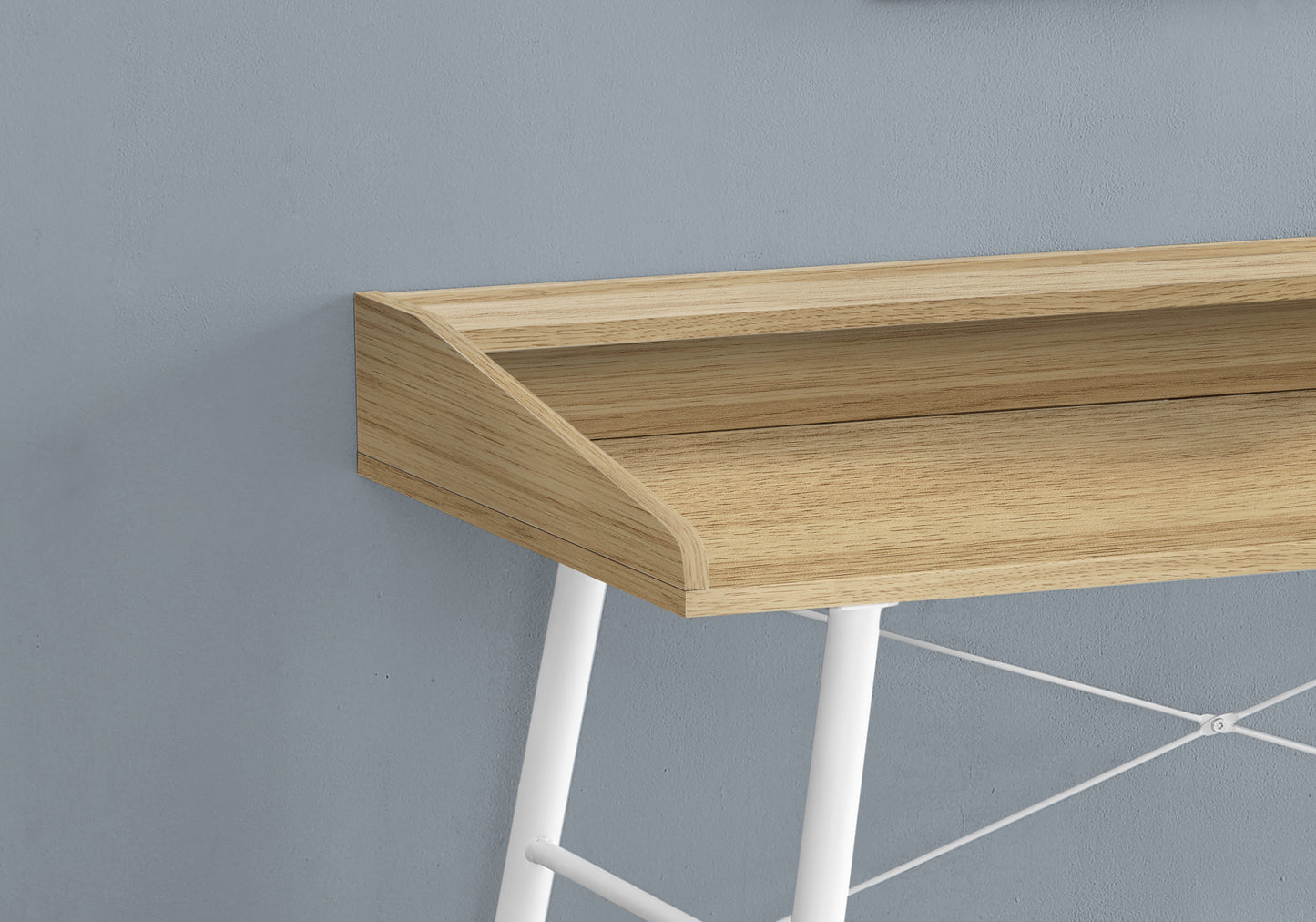 Closeup of a modern woodgrain desk surface with white metal legs and crossbars
