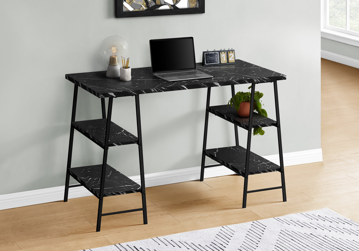 Modern black marble writing desk with integrated shelving and a laptop