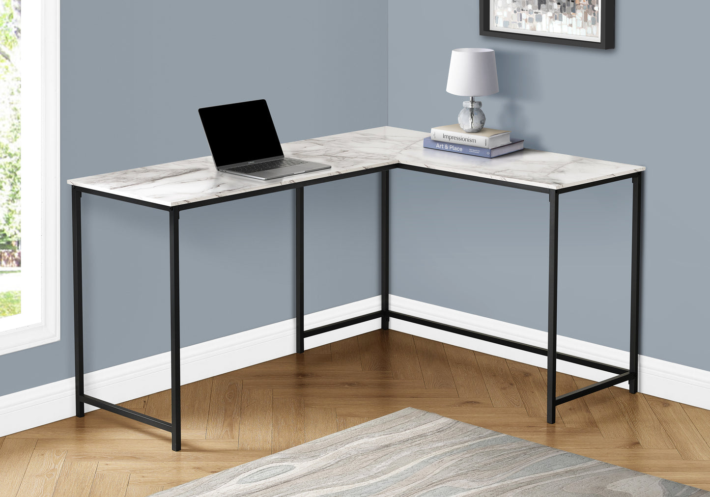 Lshaped desk with white marblelook top and black metal frame featuring a laptop