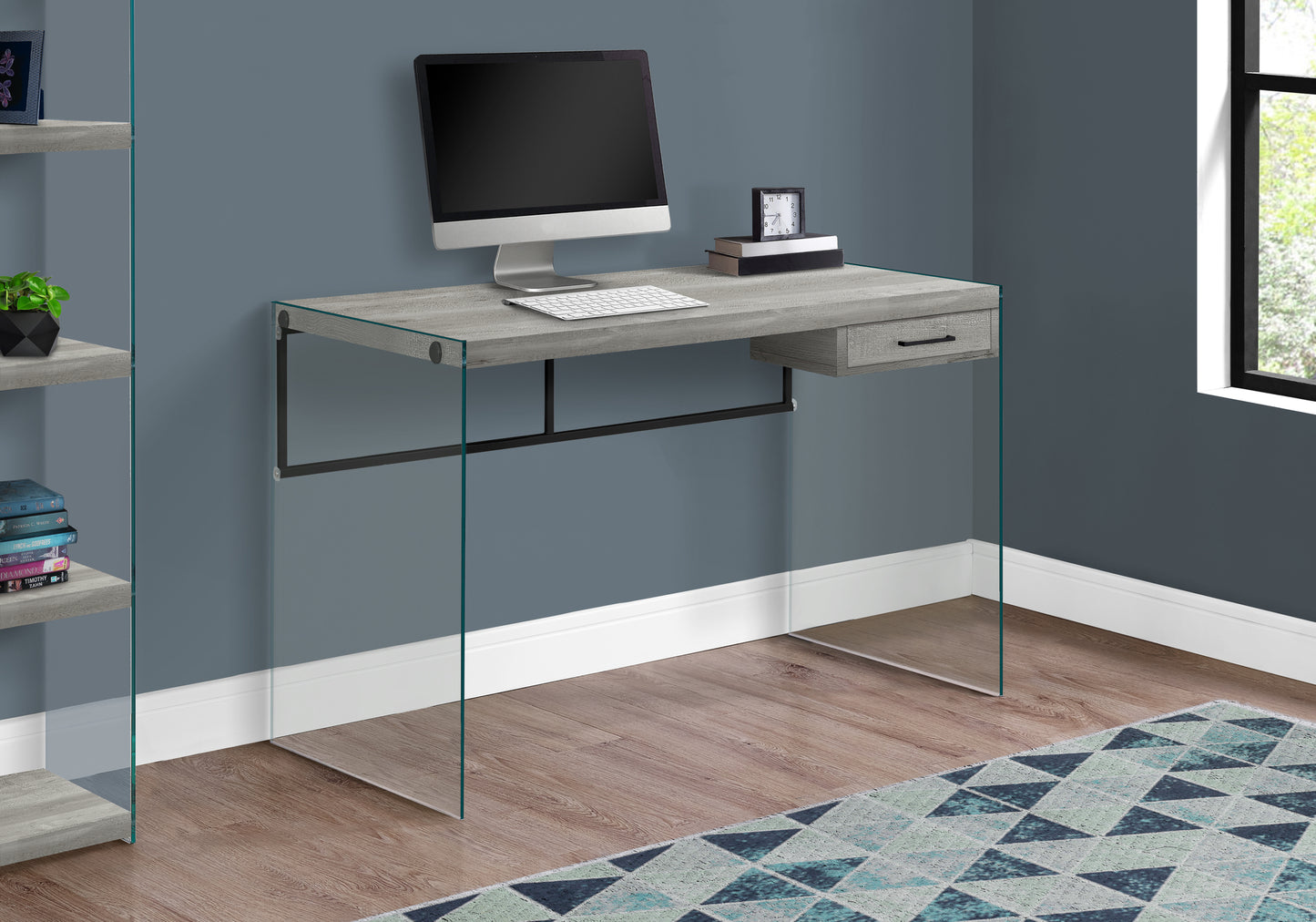 Modern grey wood computer desk with clear glass legs and single drawer