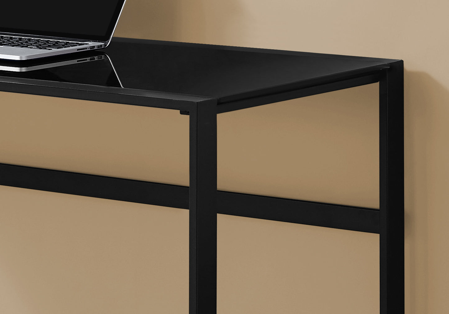 Sleek black glass desk with metal frame and laptop for a modern home office