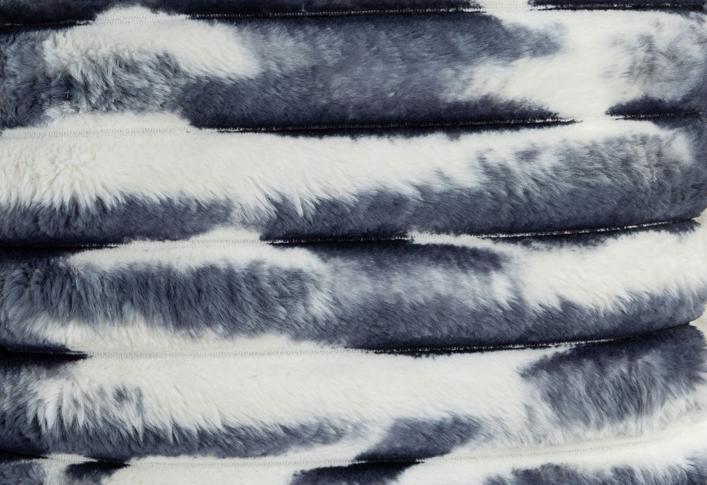 Plush faux fur throw with a cow print design in black and white perfect for cozy decor