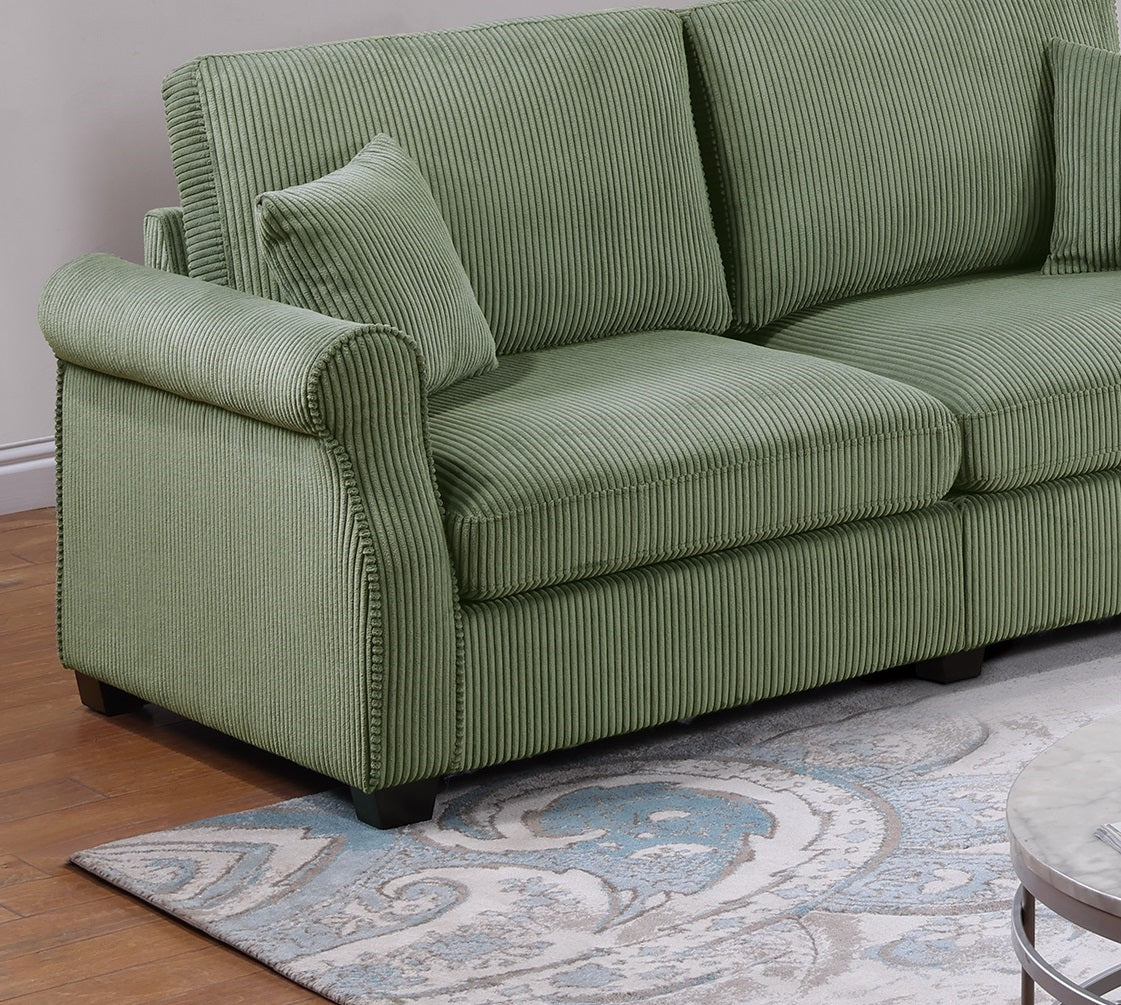 Closeup of a plush green corduroy sofa with a rolled arm and decorative nailhead trim