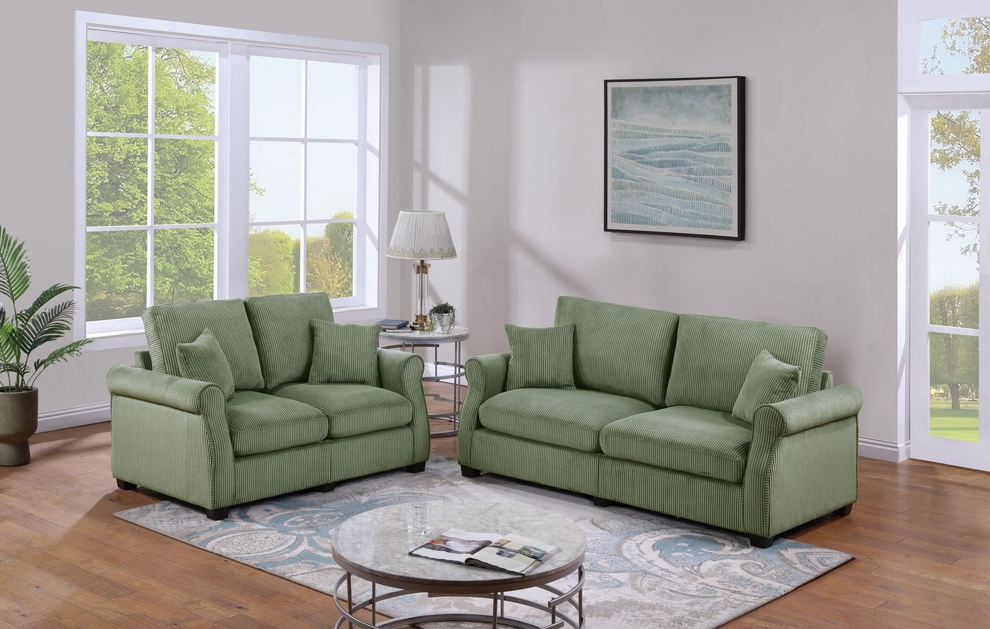 A plush sage green corduroy sofa with rolled arms and matching throw pillows sits in a living room