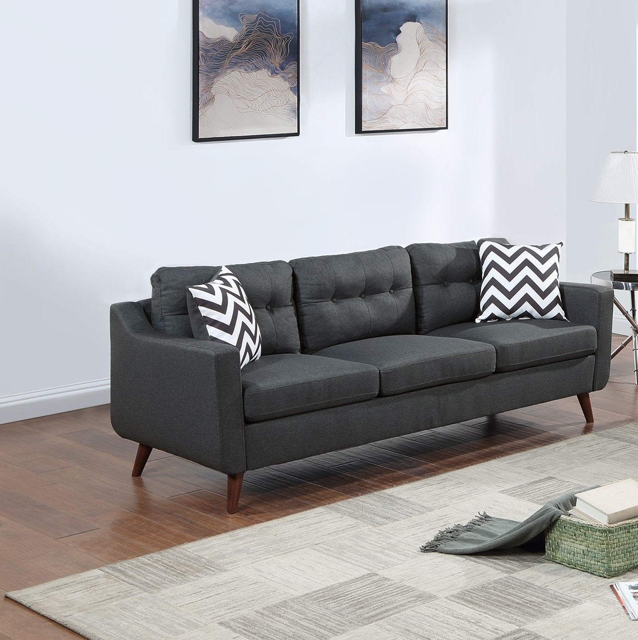 Dark grey buttontufted sofa with wooden legs and chevron throw pillows
