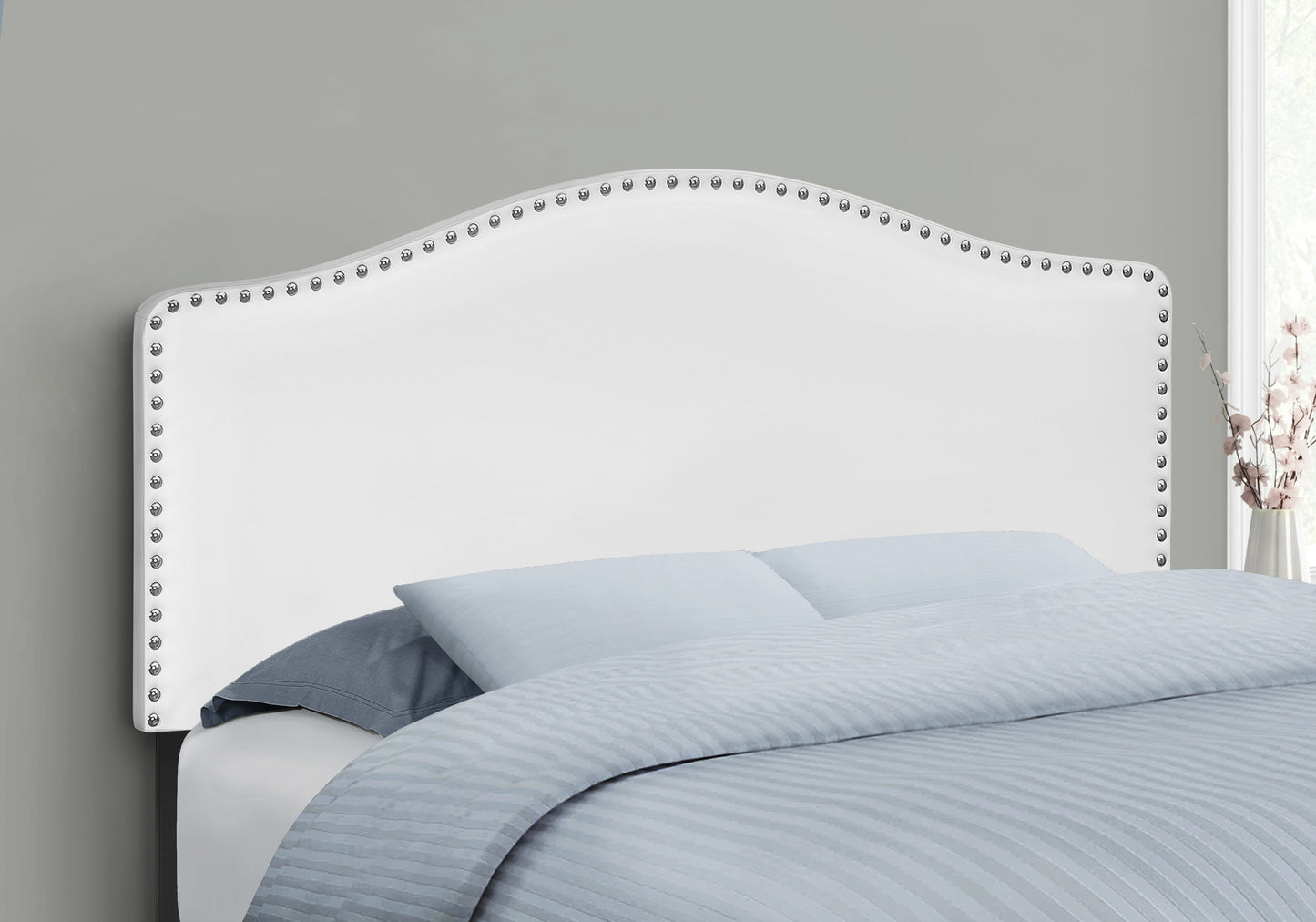 White upholstered headboard with nailhead trim