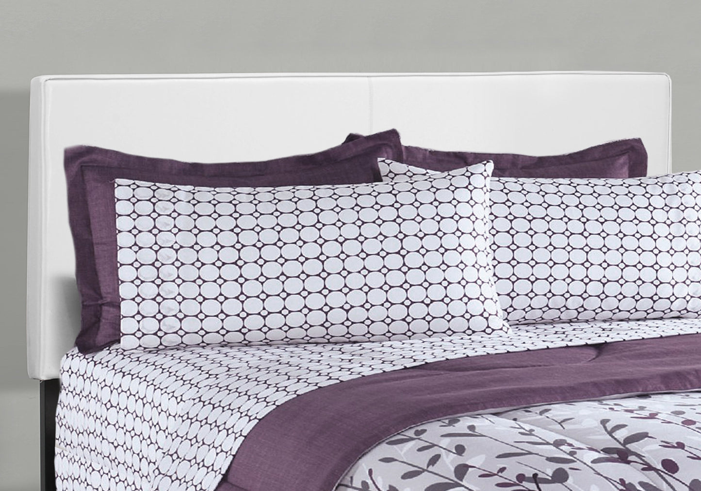 Plum and white geometric circle pattern sheet set on a bed with a white headboard