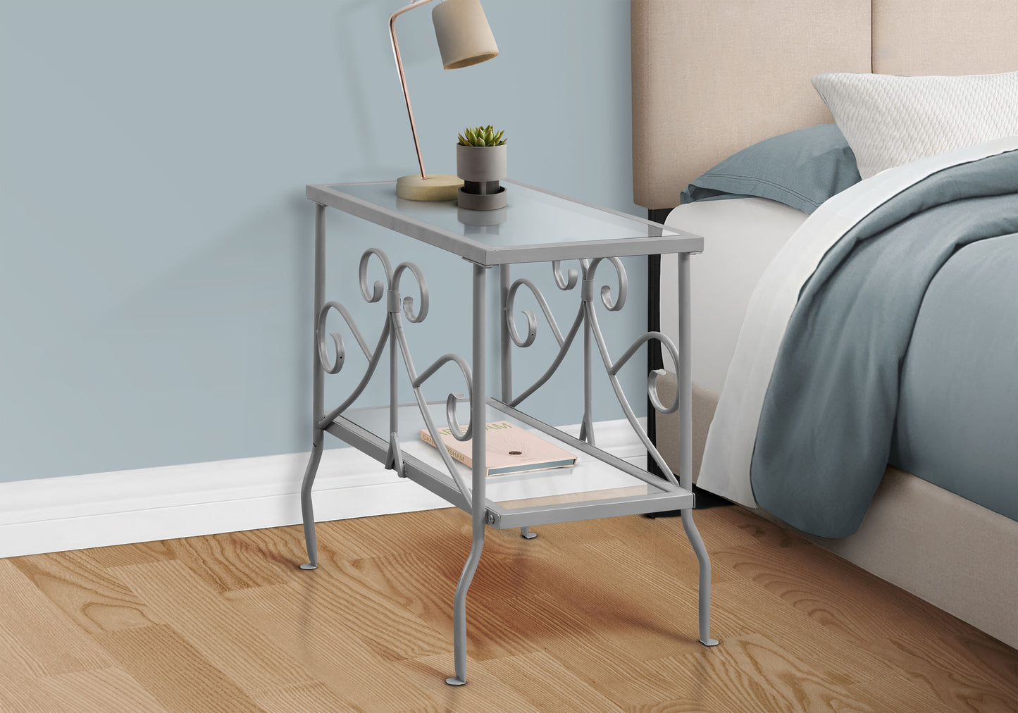 Gray metal end table with glass top and decorative scrollwork