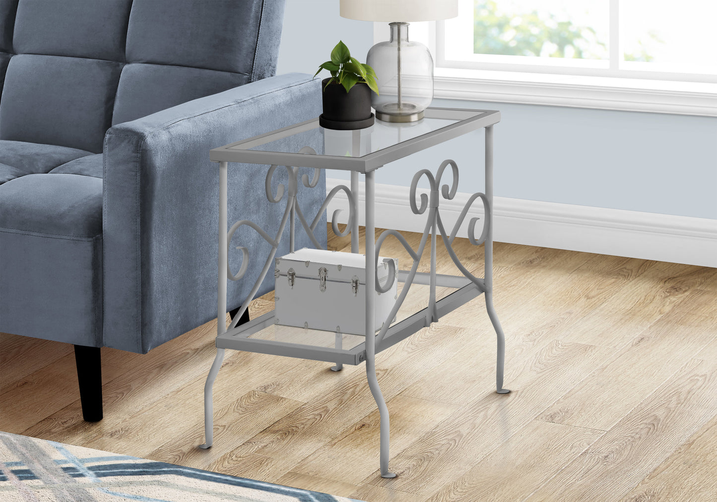 Gray metal accent table with glass top and decorative scrollwork perfect for living rooms