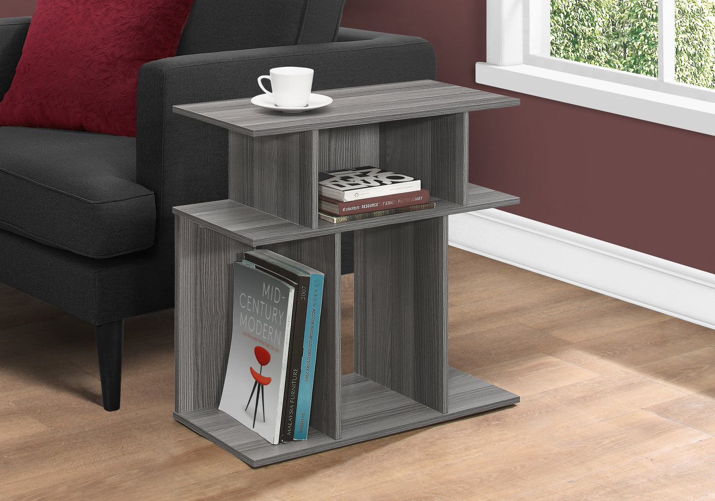 Grey wood grain Ctable with open shelves holding books and a coffee cup