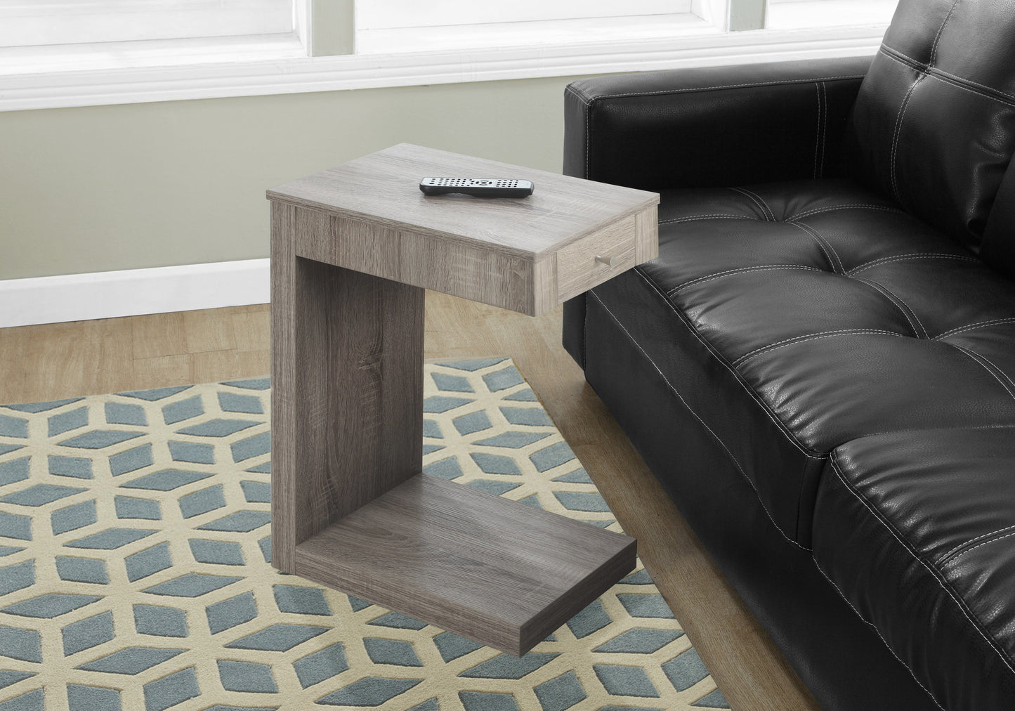 Grey wood ctable with drawer next to black leather sofa for living room