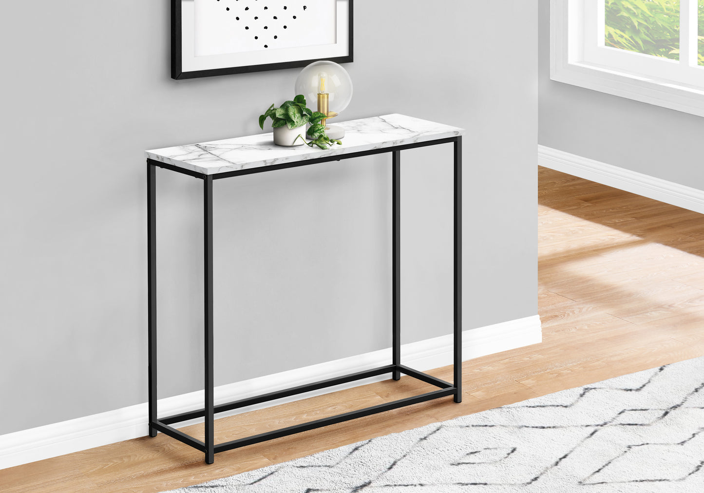 Slim black metal frame console table with white marble top and gold lamp accent