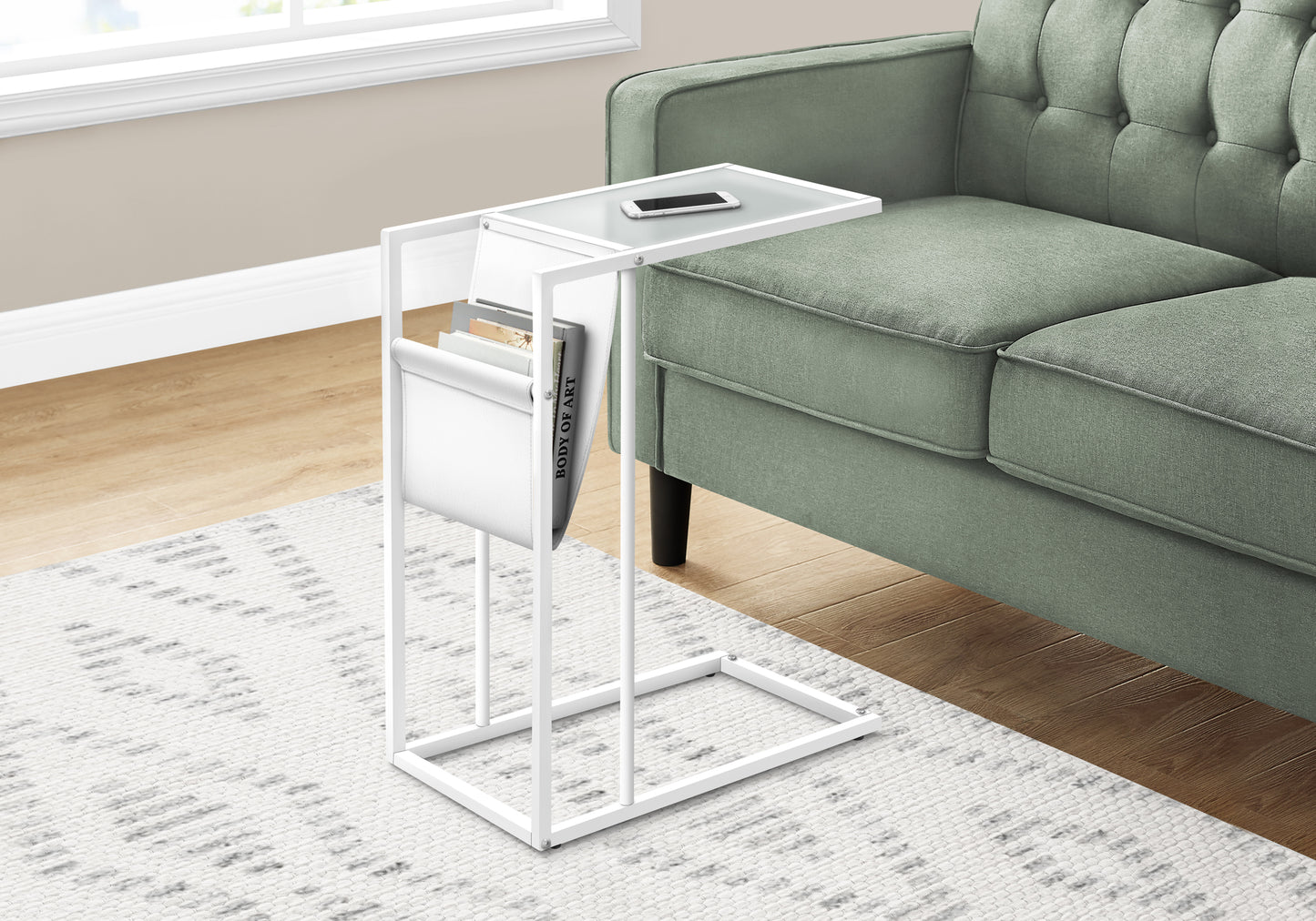White ctable with frosted glass top holding a smartphone next to a green sofa
