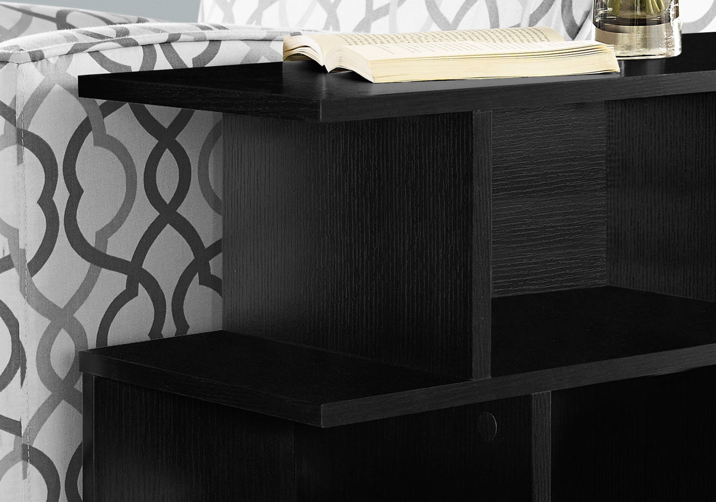Black wood side table with an open shelf and a book on top