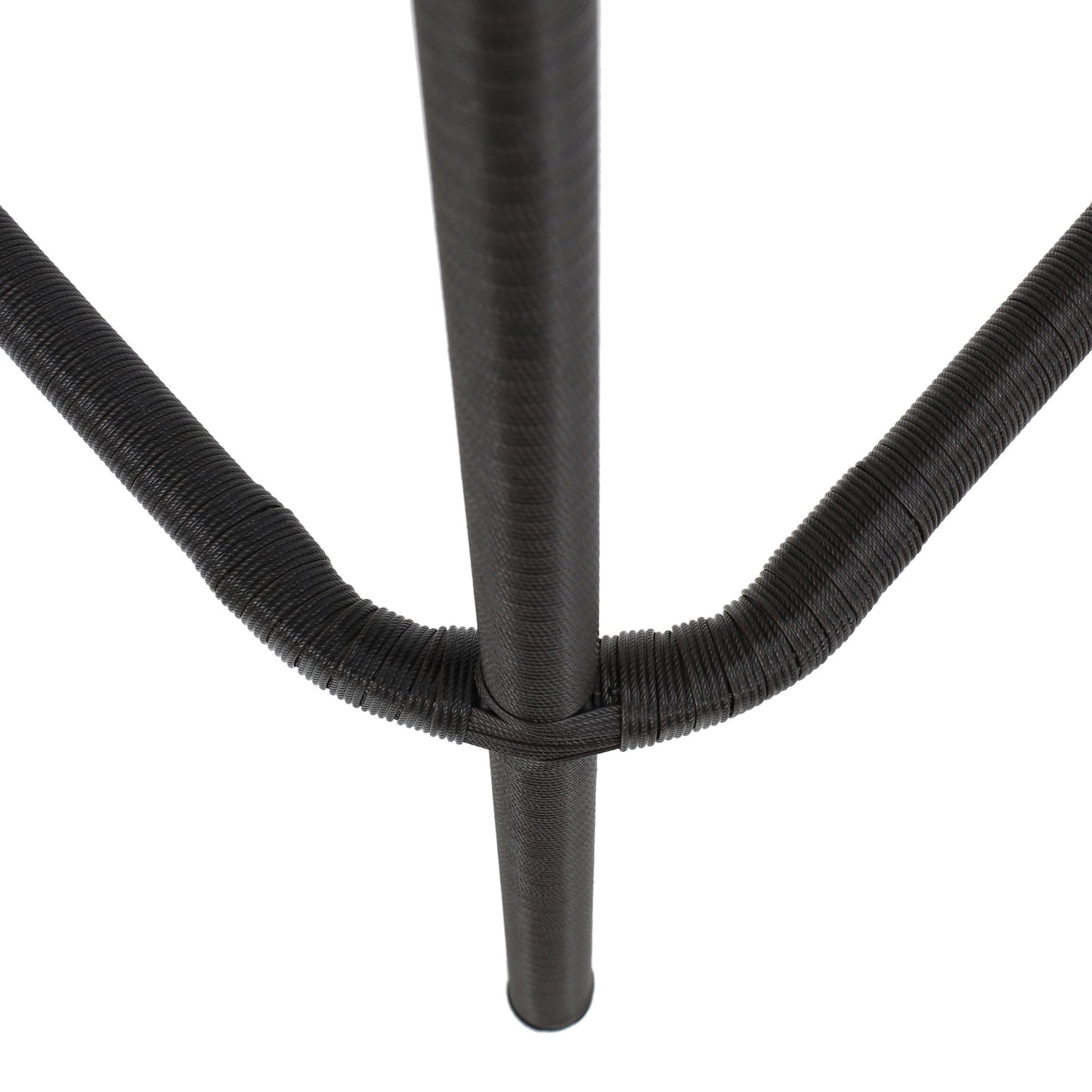 Closeup of dark brown woven rattan texture on a chair leg