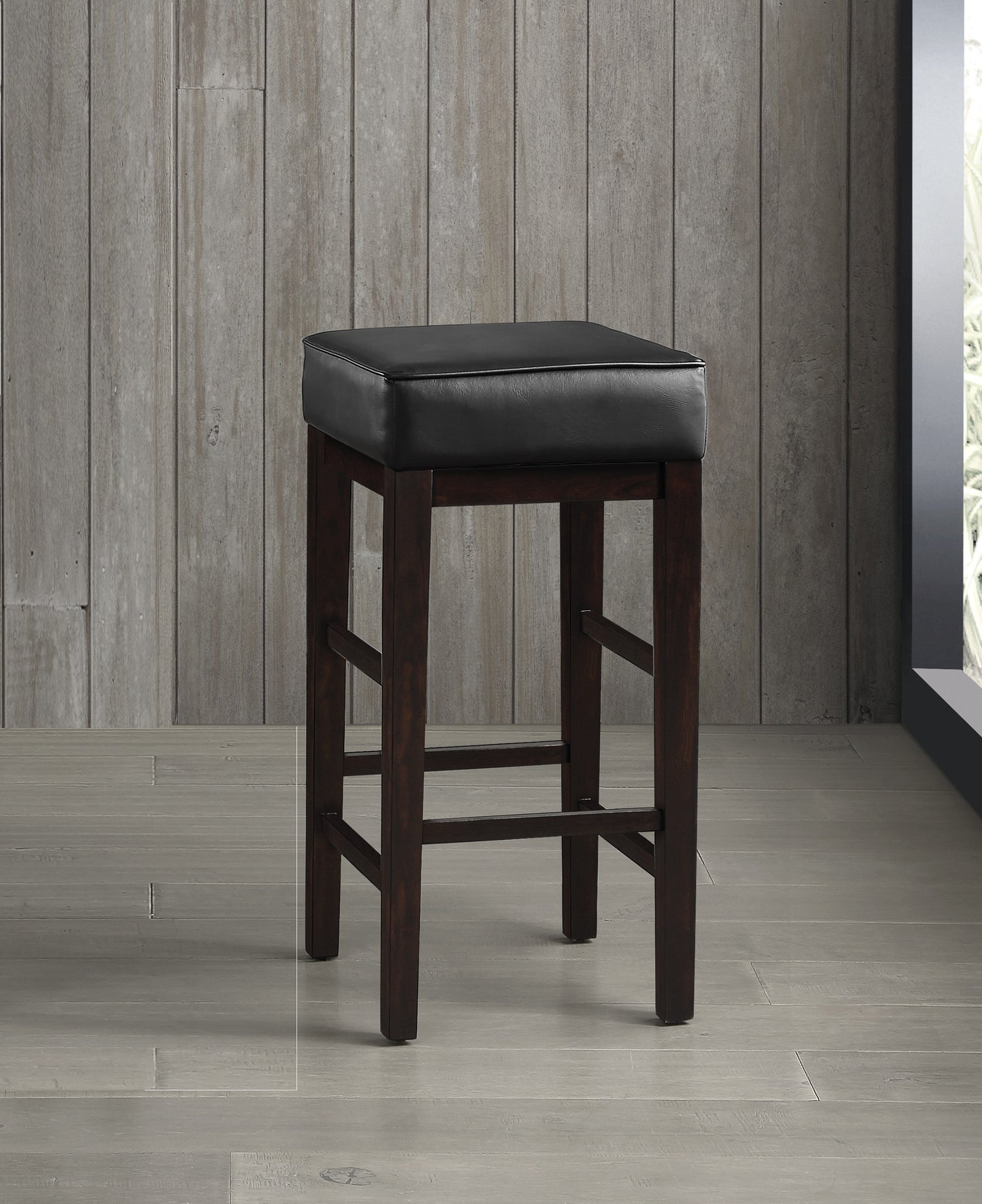 Dark brown wooden bar stool with padded black leather seat and footrest