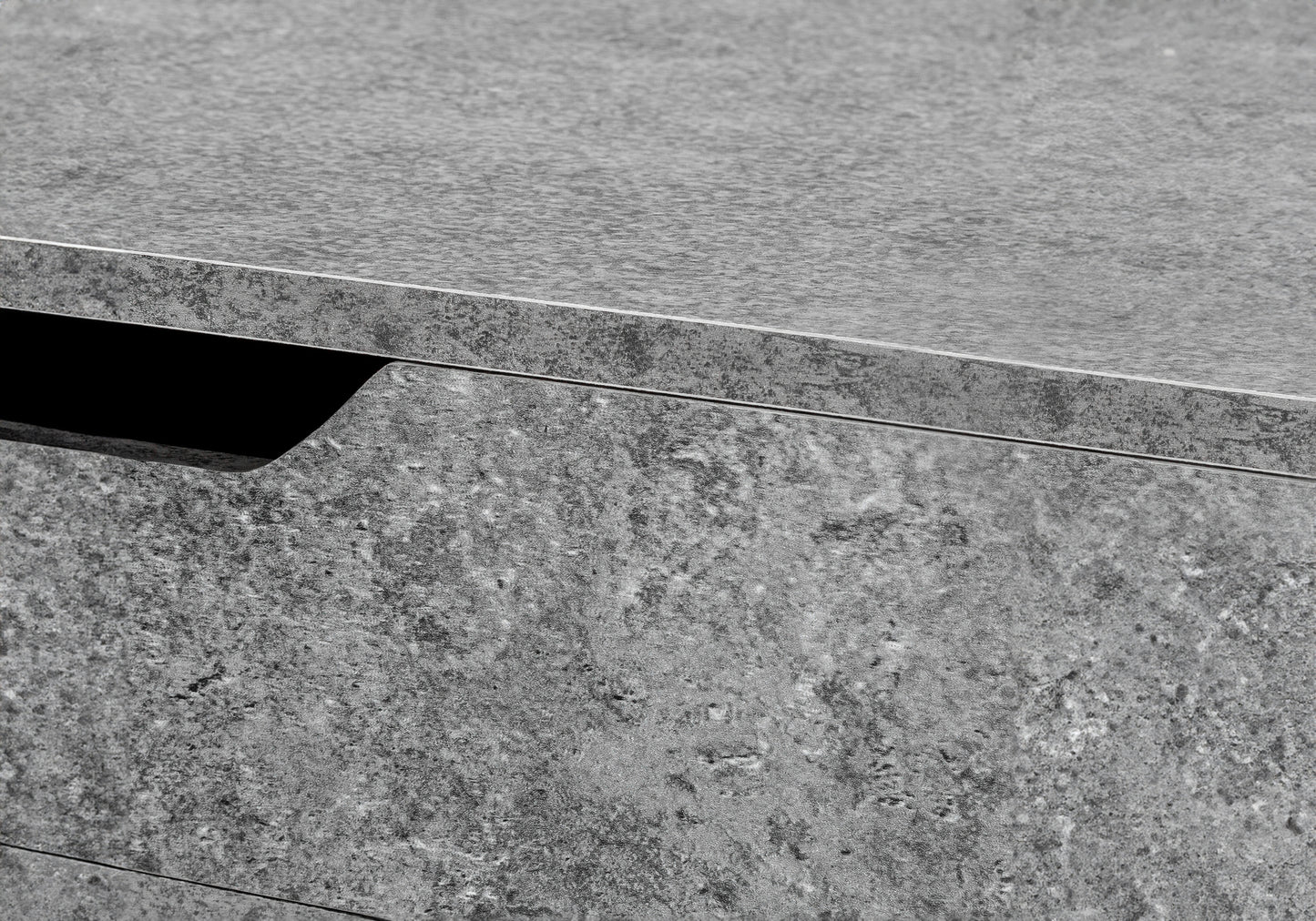 Closeup of textured gray concrete drawer front with integrated handle recess