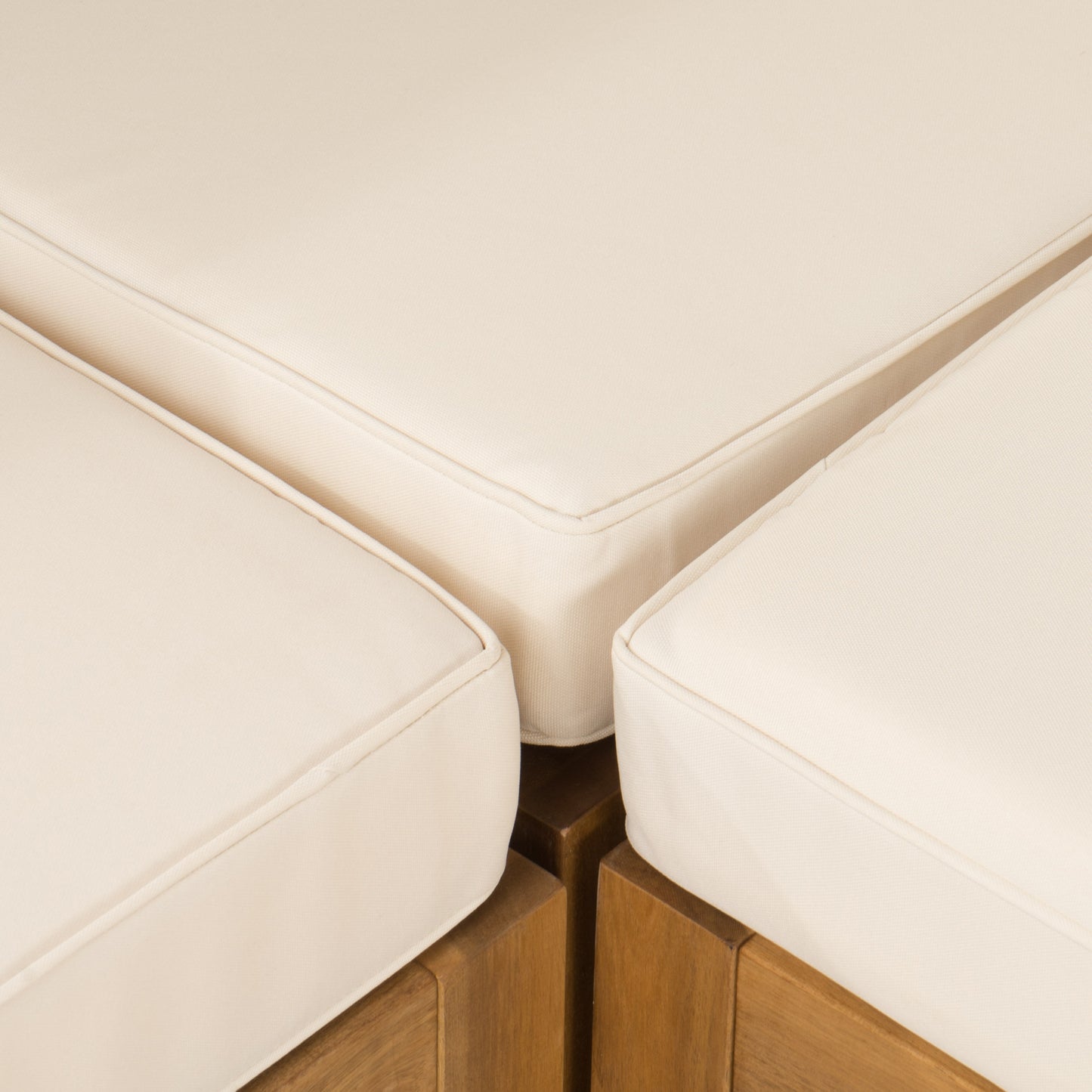 Closeup of plush cream outdoor sofa cushions with wooden base detailing