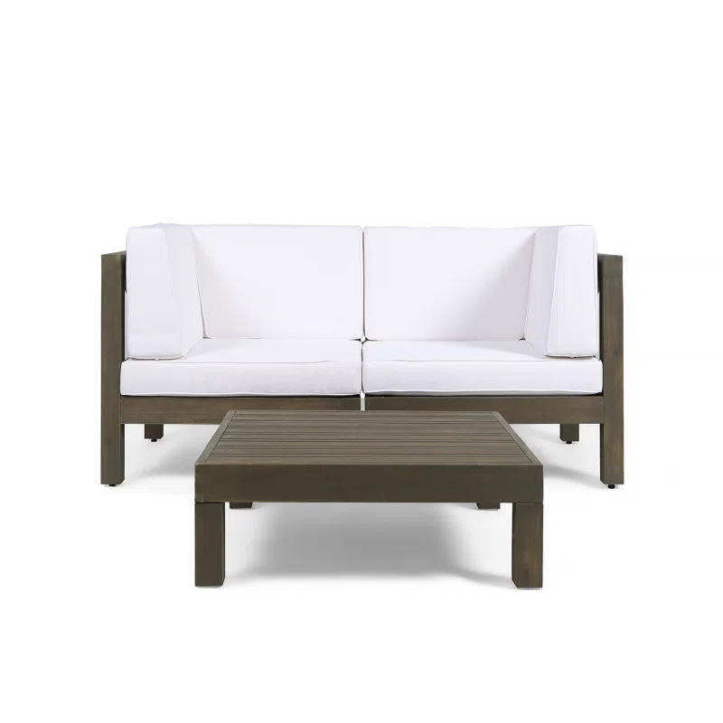 Modern outdoor loveseat with white cushions and dark wood frame paired with slatted coffee table