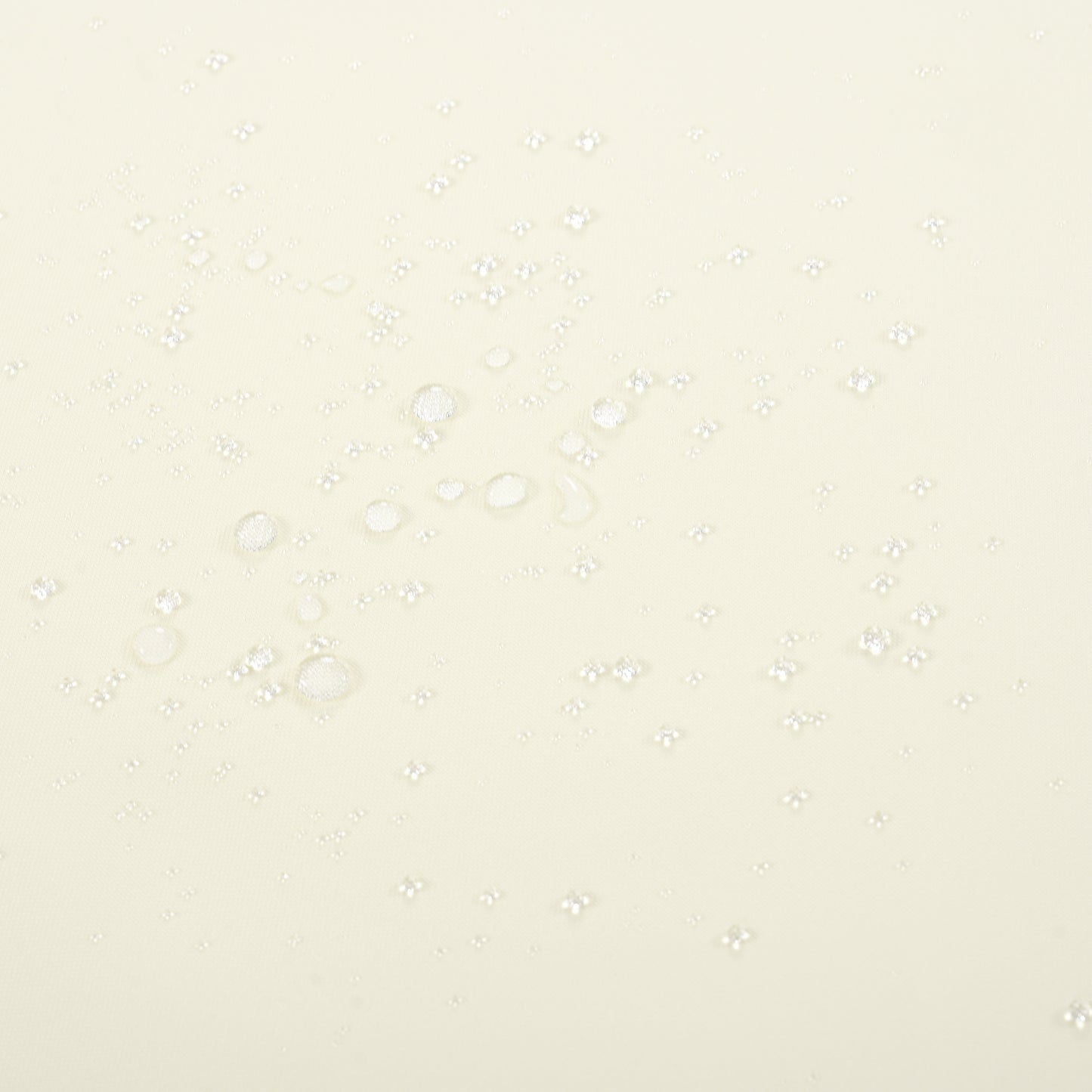 Closeup of translucent water droplets on a creamcolored fabric surface