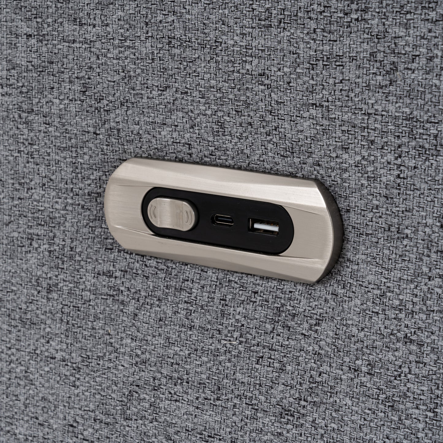 Builtin USB charging port and button on gray textured sofa fabric