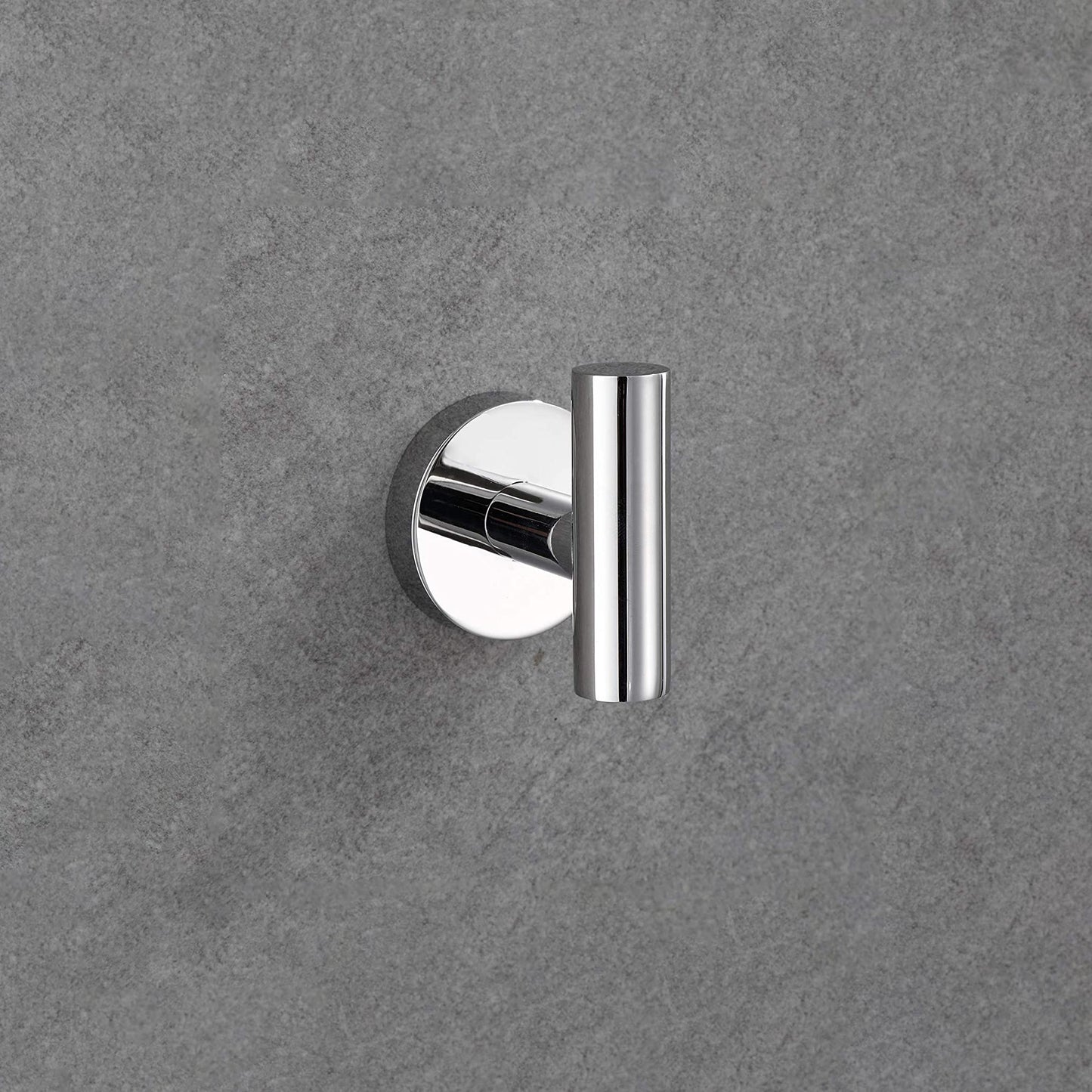 Polished chrome single robe hook on textured grey wall