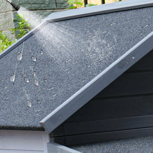 Grey textured asphalt shingle roof detail showing water beading demonstrating weatherproofing