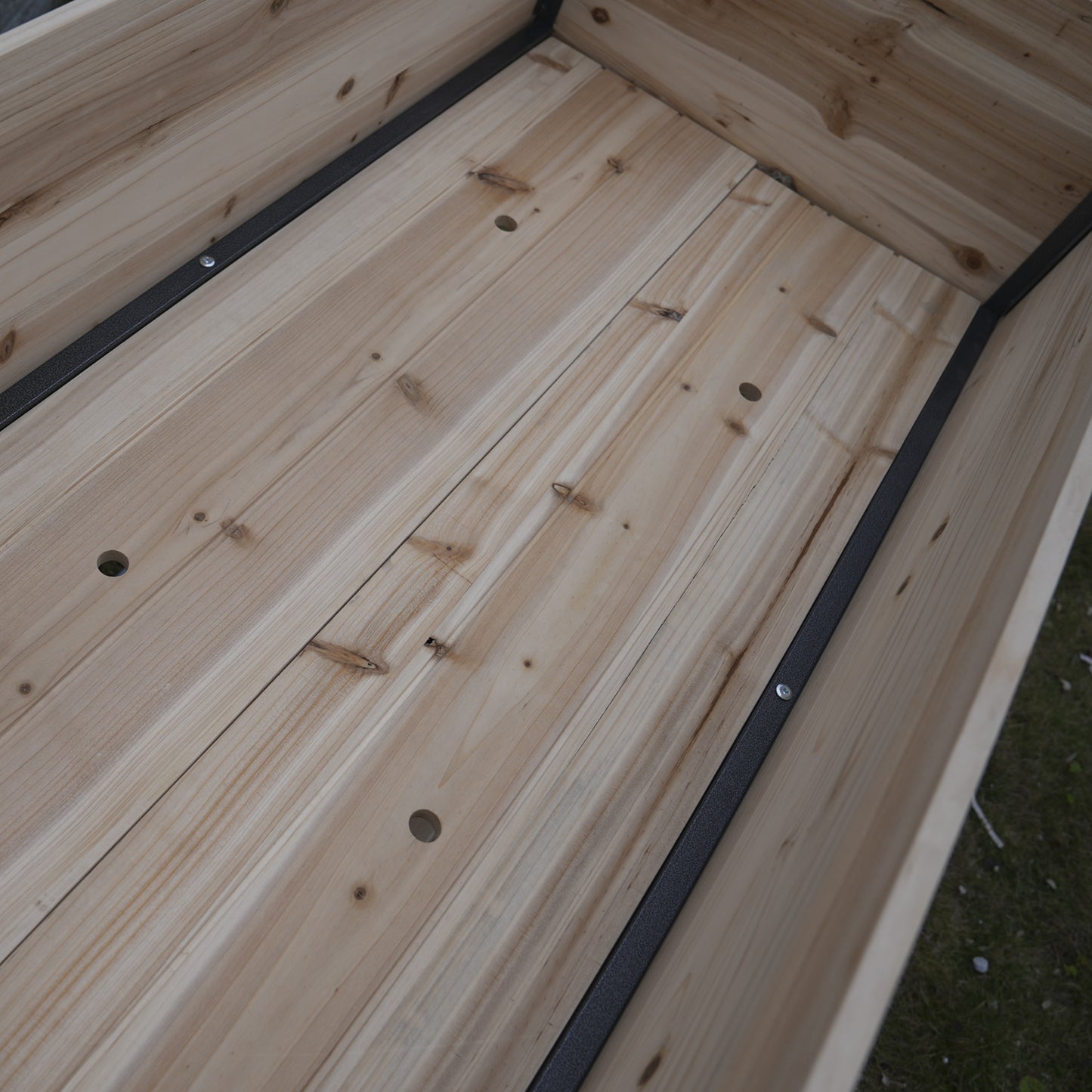 Wooden raised garden bed with slatted floor and metal corner supports