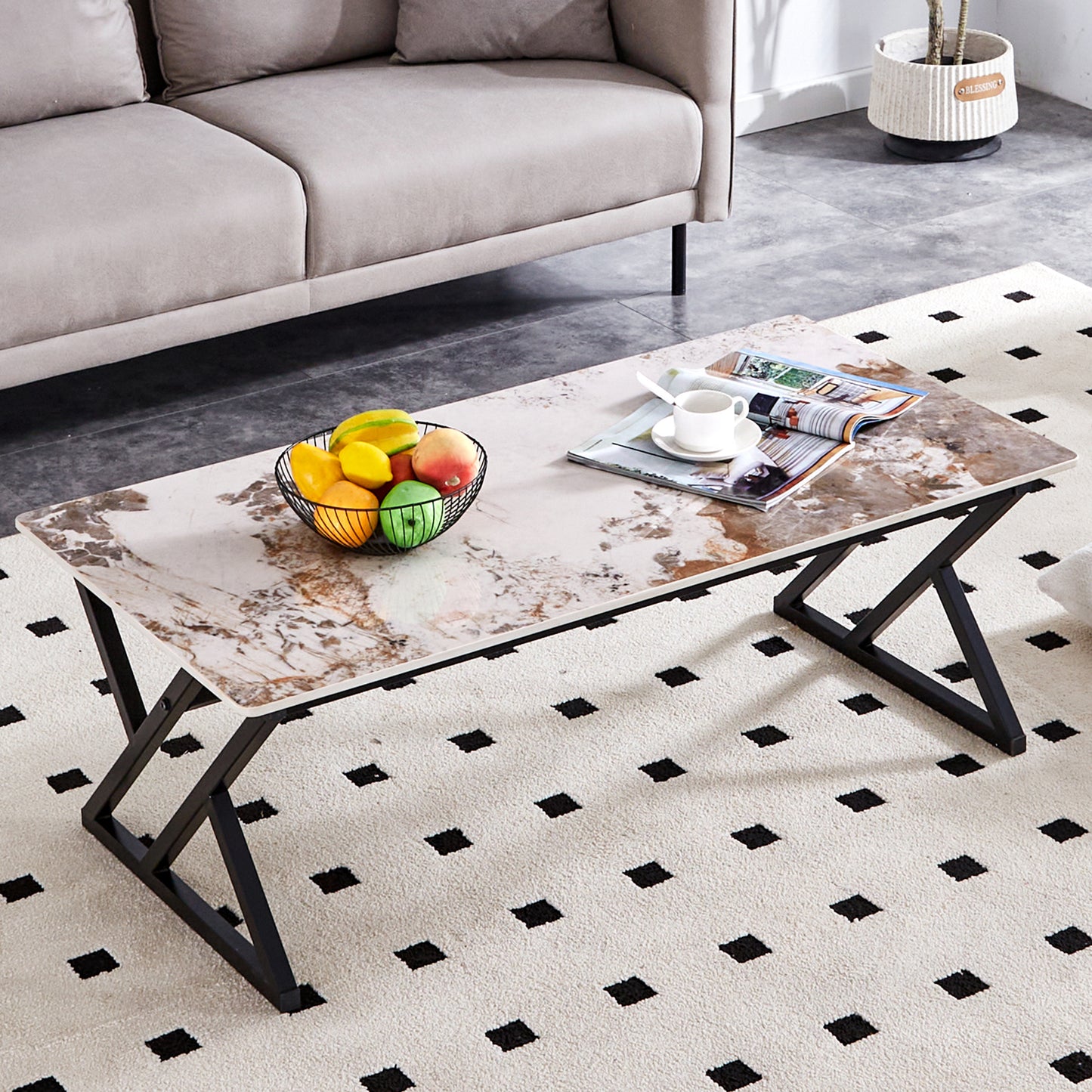 Marble pattern coffee table with black metal legs and a fruit bowl