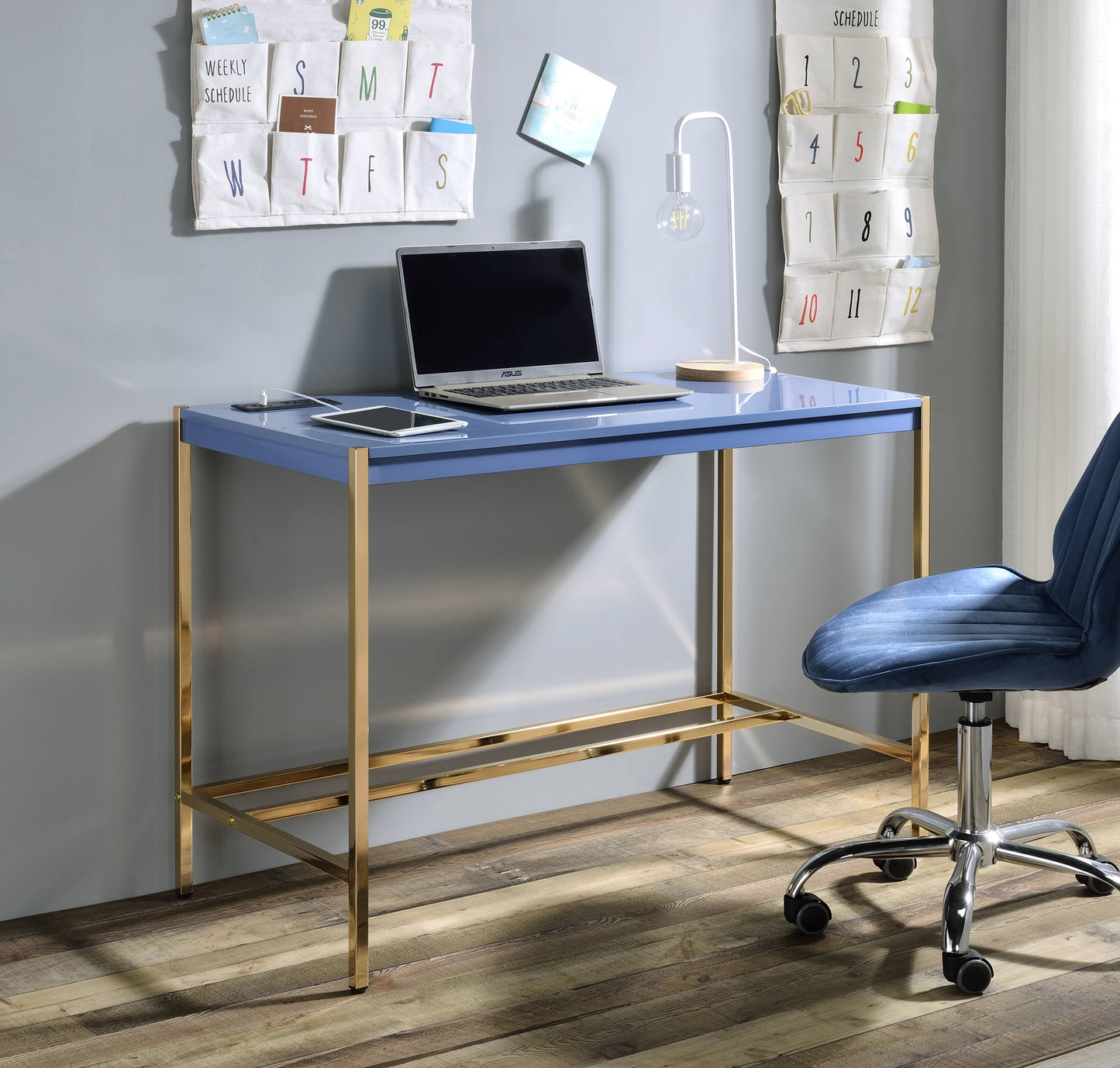 Blue executive desk with gold legs and a laptop and tablet setup