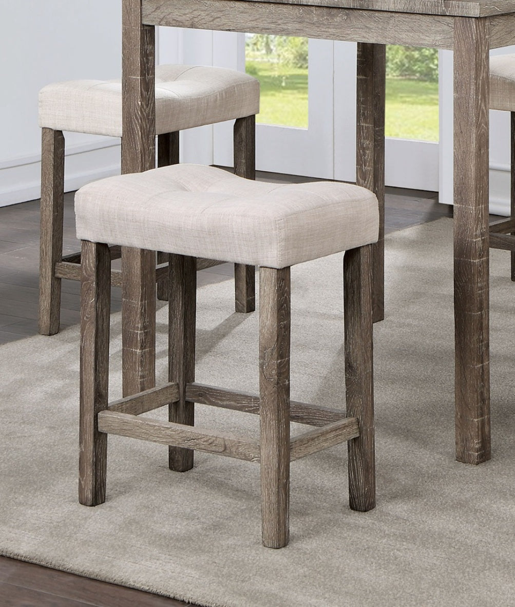 Tufted linen counter stool with distressed wood legs and a neutral upholstered seat