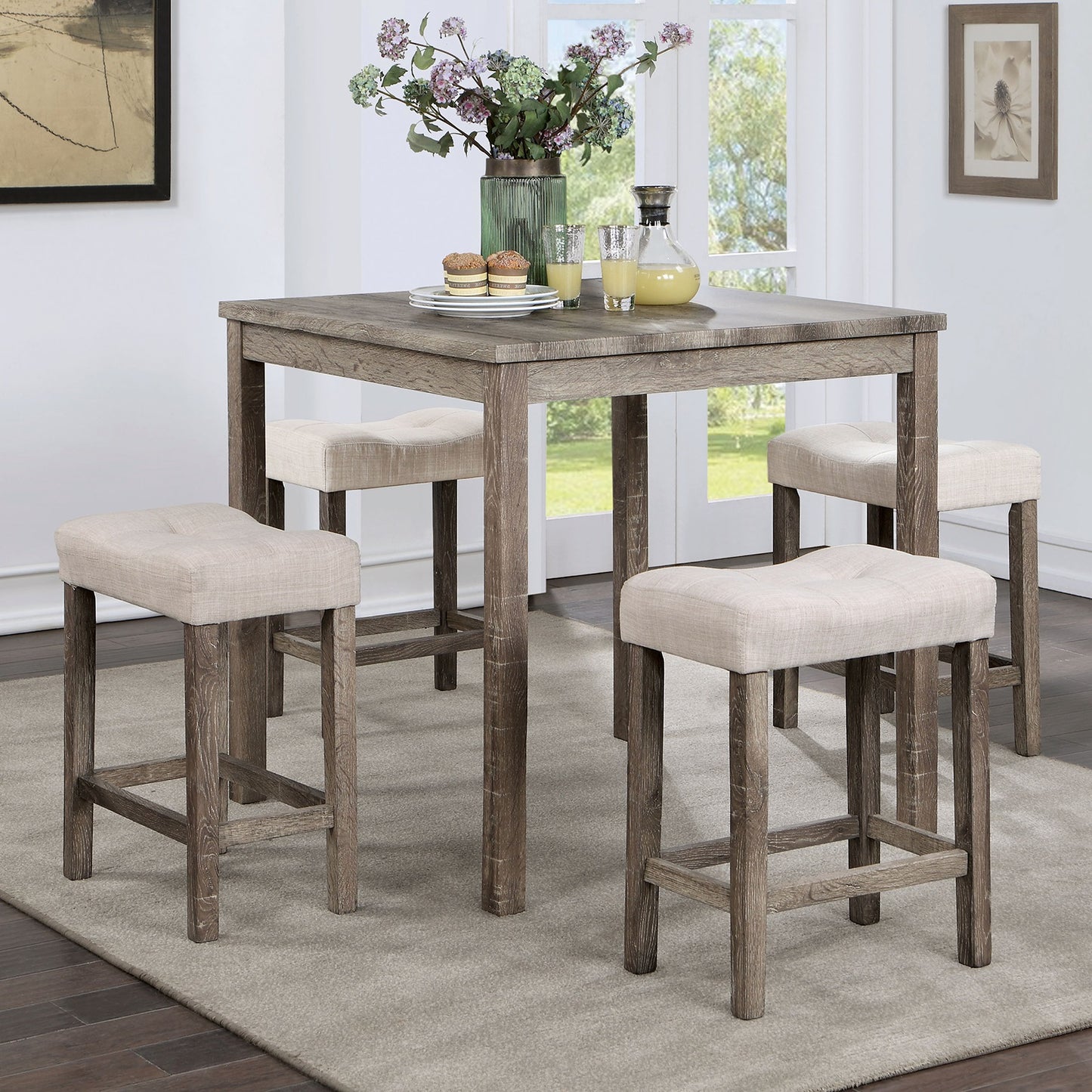 Rustic gray wood counter height table with four tufted beige stools ideal for small dining spaces