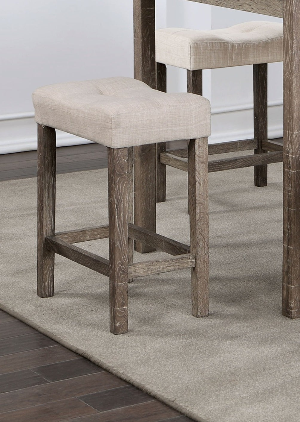 Tufted beige linen counter stool with distressed wood legs and footrest