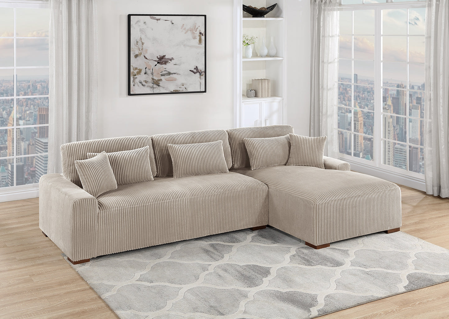 Beige corduroy sectional sofa with plush throw pillows on a grey patterned rug