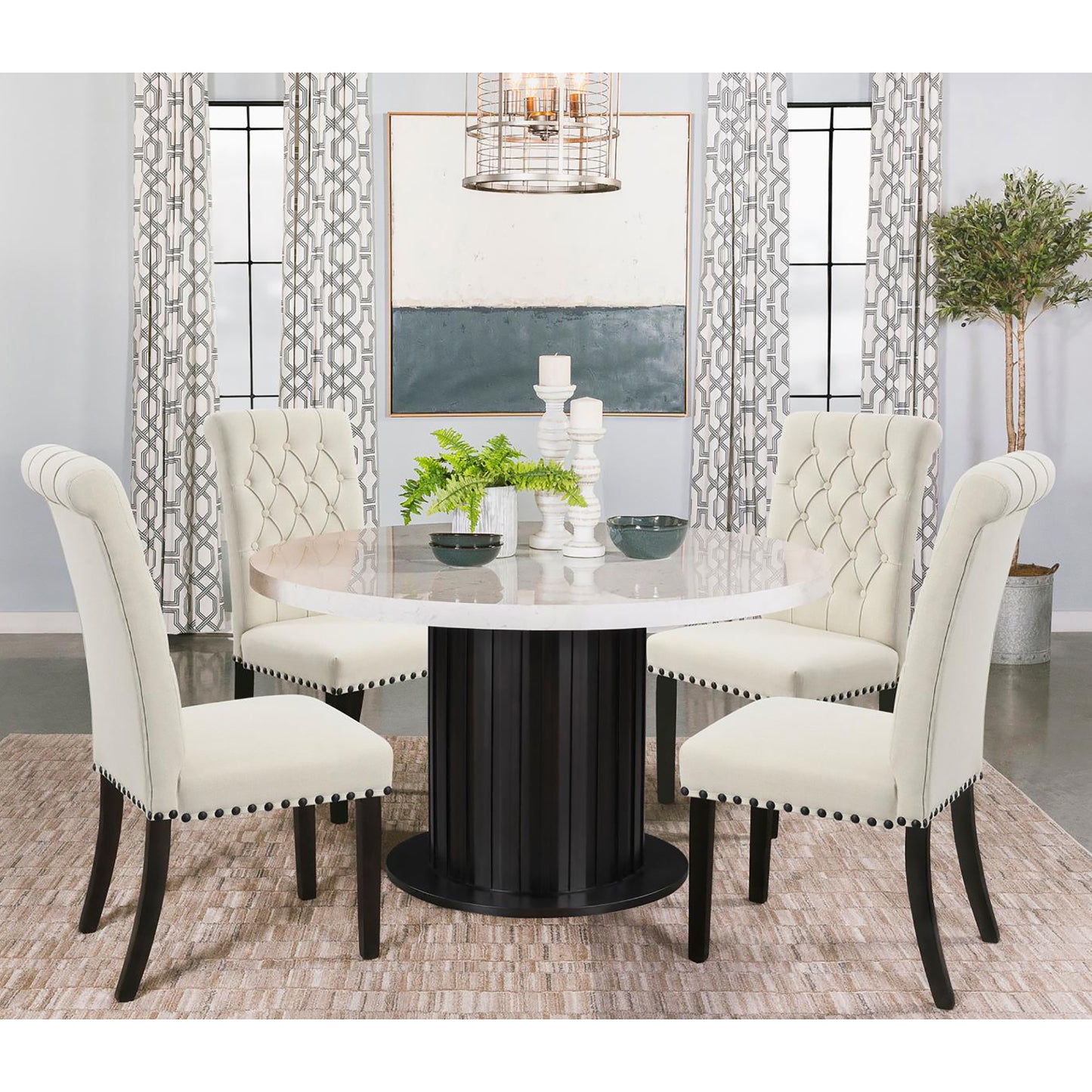 Tufted cream dining chairs with nailhead trim surround a round marbletop table with a dark wood pedestal